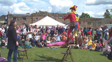 Kris balancing a volunteer on a plank lying on a single chair back.