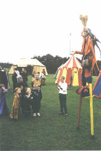 Kris entertaining the children at a medieval wedding balancing a plastic sword on his finger whilst on his stilts.