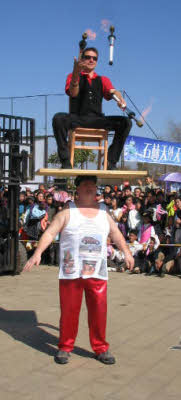 John Evans balances a juggler on his head