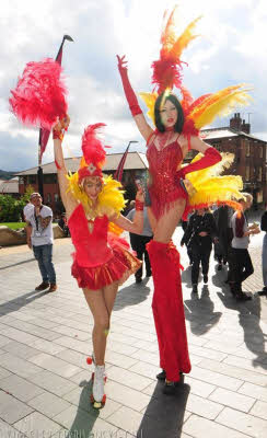 Carnival stiltwalker and roller girl
