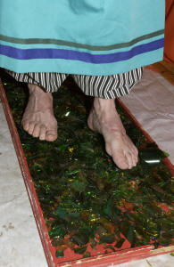 Mustapha Payne walks barefoot on broken glass